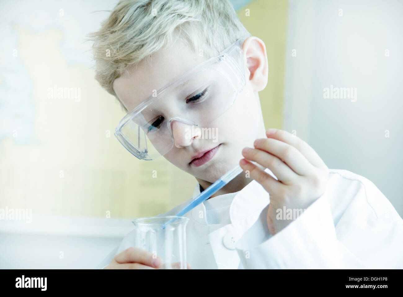 Boy wearing safety goggles doing science experiment Stock Photo Alamy