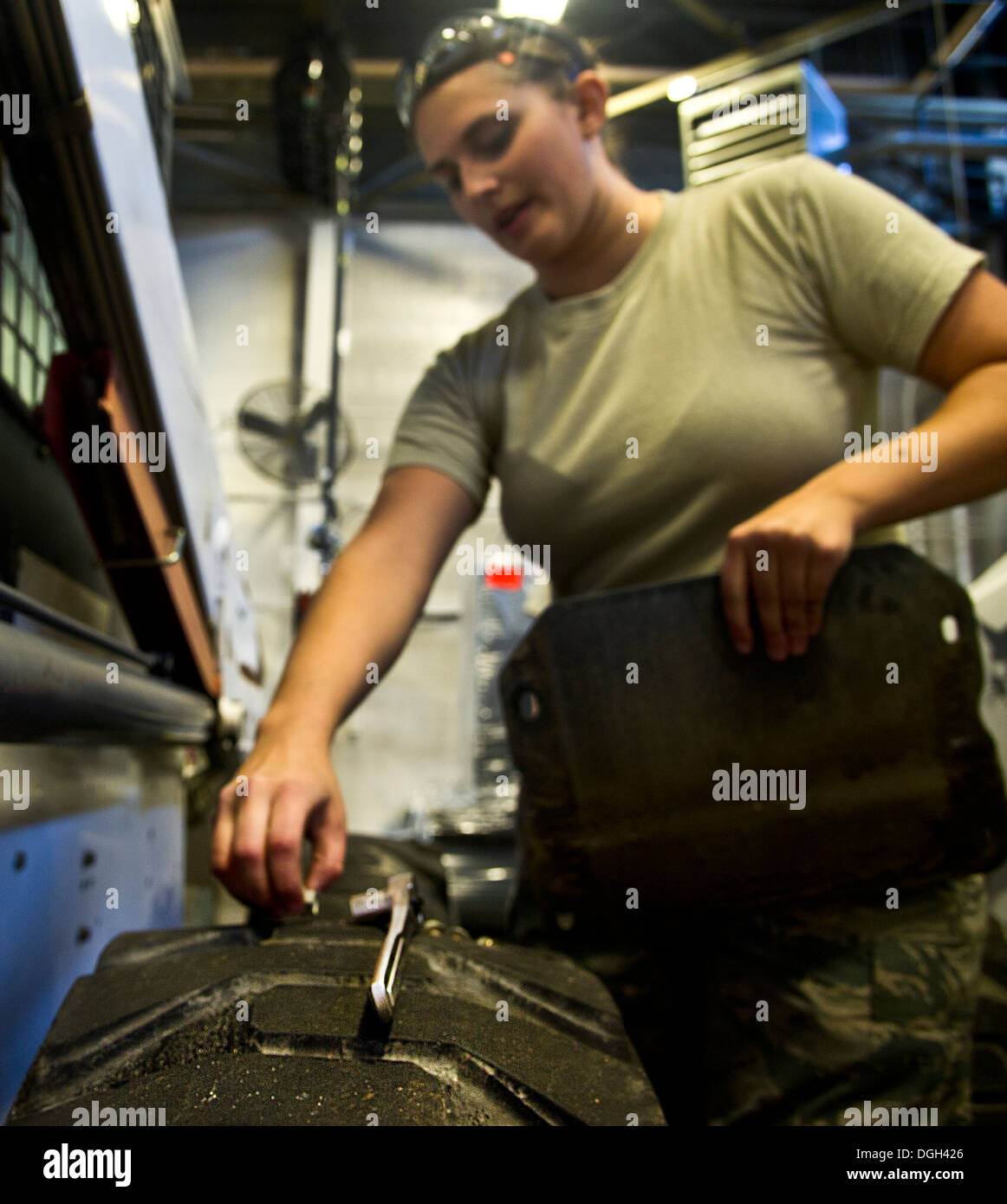 Airman 1st Class Johanna Desimone, 5th Logistics Readiness Squadron vehicle maintainer, puts the side panel on a loader at Minot Air Force Base, N.D., Oct. 16, 2013. The 5th LRS vehicle maintenance flight repairs and maintains various types of vehicles to Stock Photo