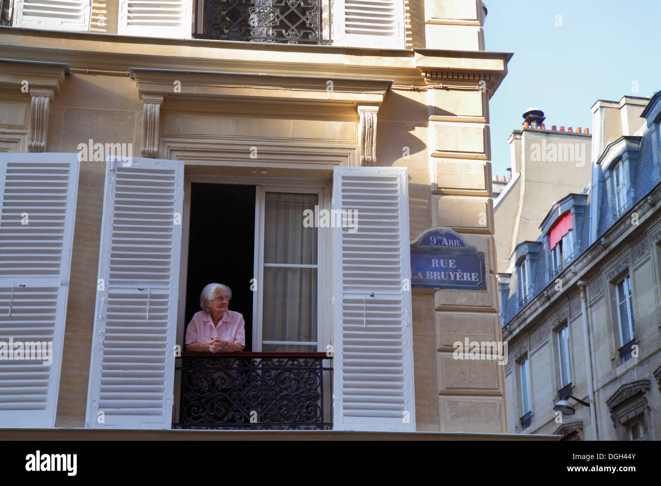 Paris France,9th arrondissement,Rue La Bruyere,senior seniors citizen citizens,adult,adults,woman female women,window,shutters,historic Haussmann cond Stock Photo