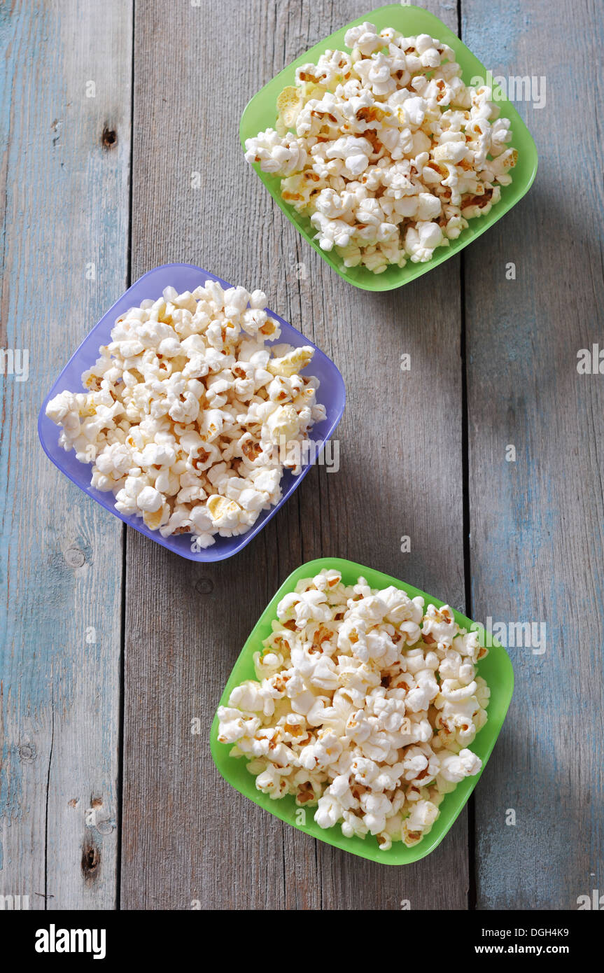 Popcorn in plastic bowls over wooden background Stock Photo