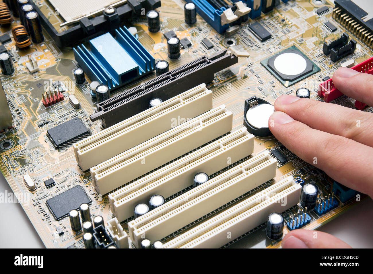 Hand install battery to PC motherboard Stock Photo