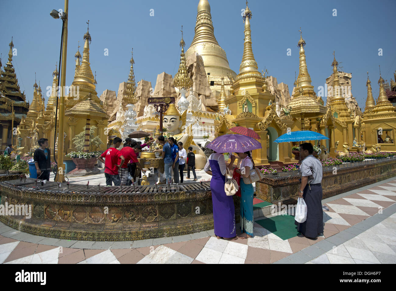 People with umbrellas at Buddhist gilded pagoda and stupa, Shwedagon Pagoda, Yangon, Myanmar, March Stock Photo
