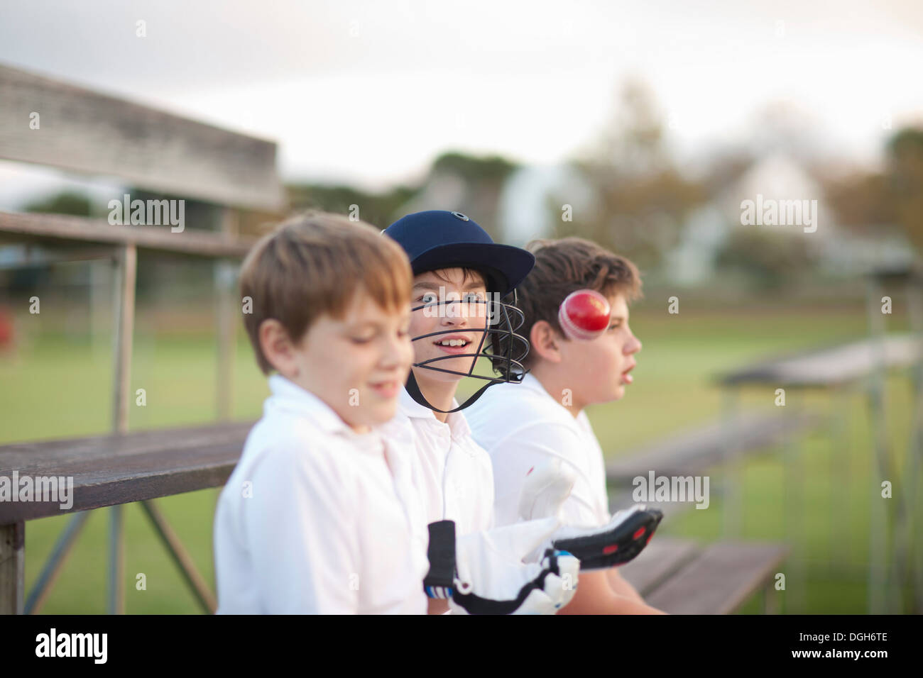 Boys on bleachers at cricket pitch Stock Photo