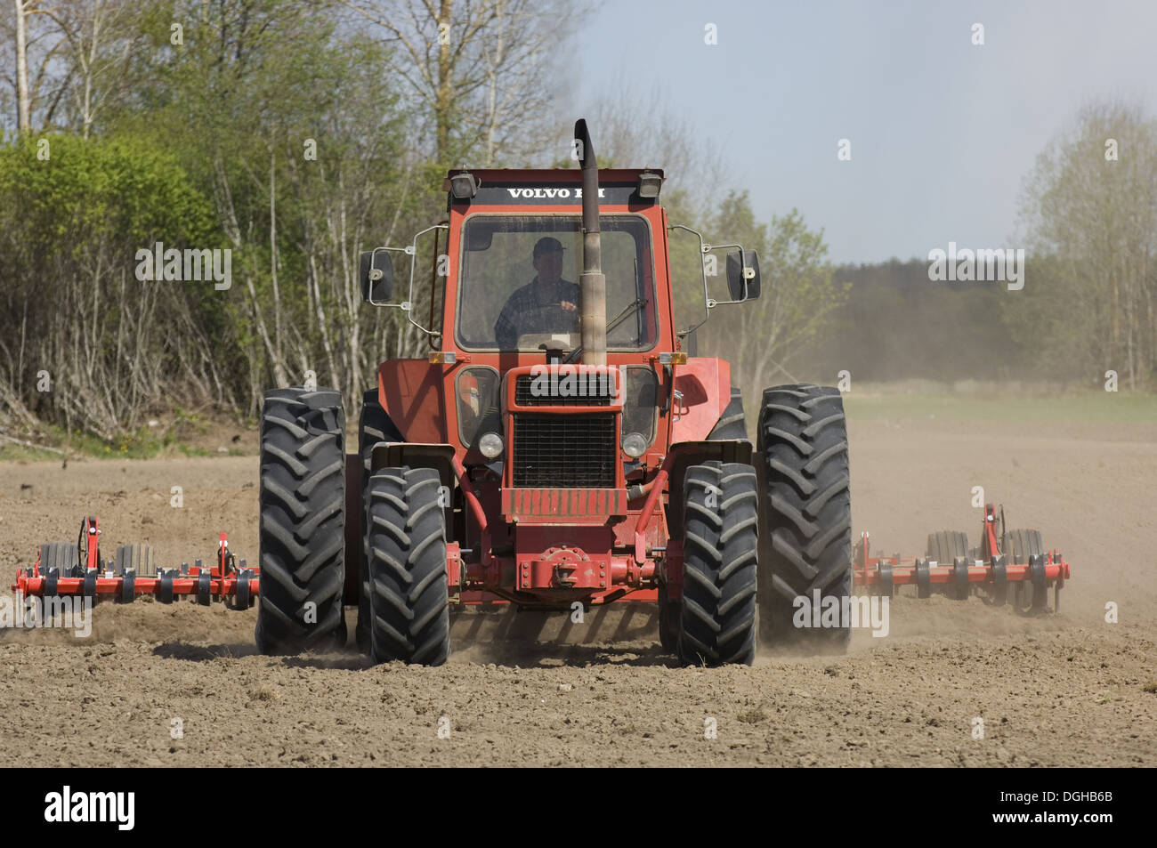 Volvo tractor pulling harrows, cultivating arable field, Sweden Stock Photo