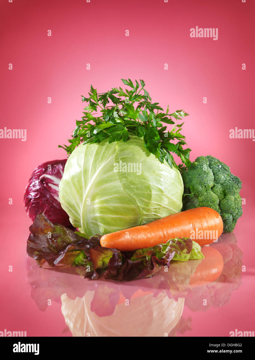 Colorful vegetable healthy food still life, cabbage and greens on bright pink background Stock Photo