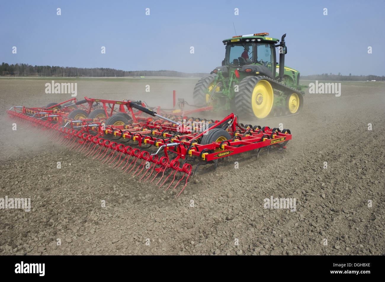 John Deere 8320 RT tracked tractor with Vaderstad NZA-1000 harrows, harrowing arable field, Sweden, april Stock Photo