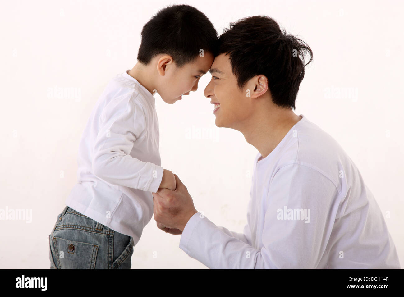 East Asian father and son hand in hand, head to head Stock Photo