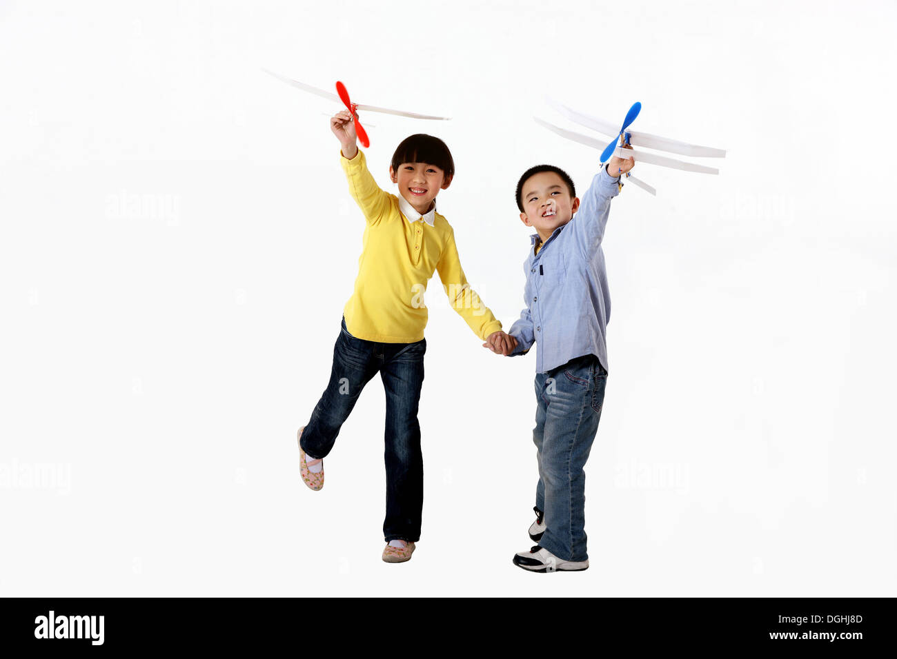 East Asian Boy and Girl Hand in Hand, Playing Model Airplane Stock Photo