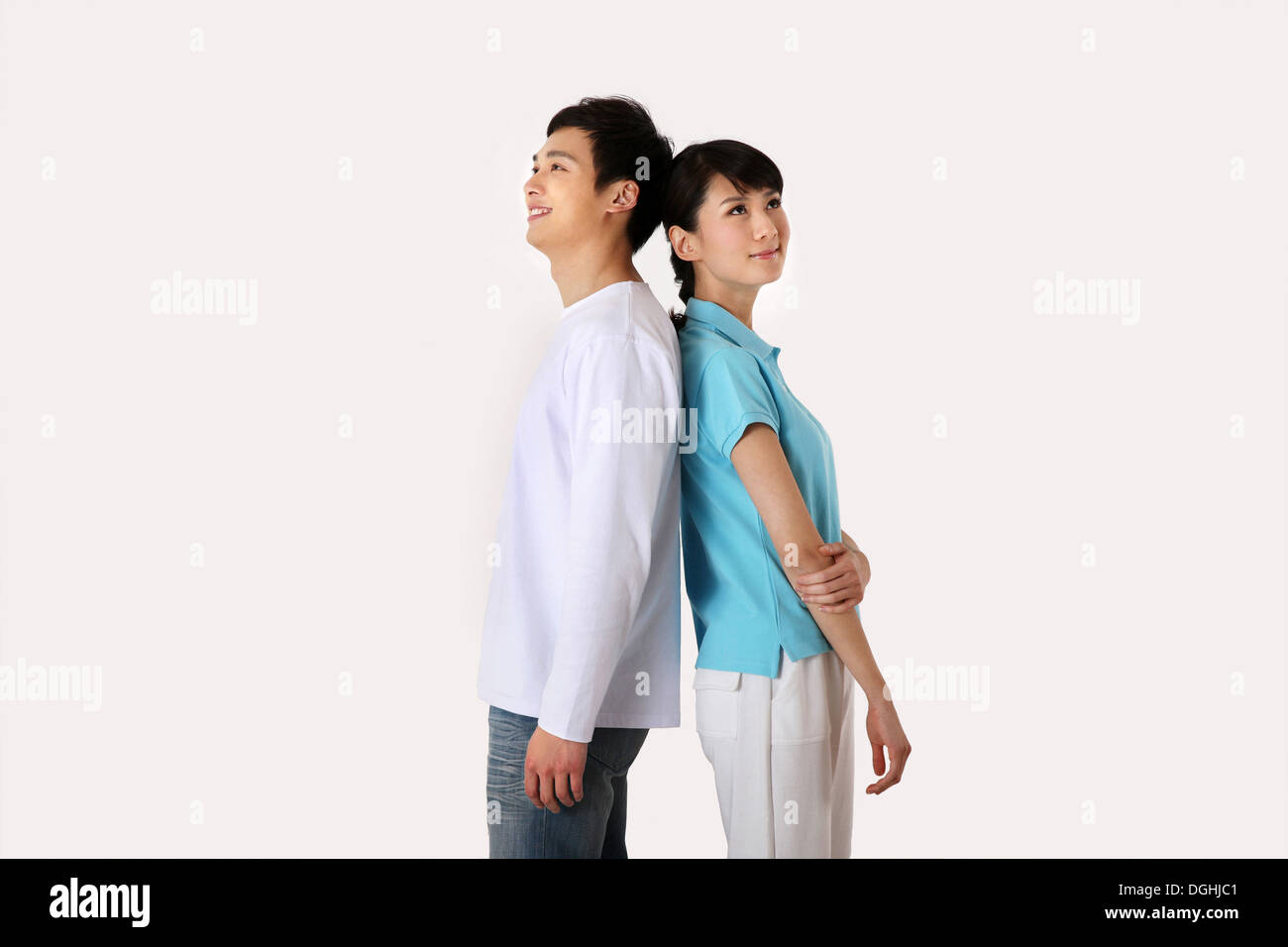 East Asian couple in casual clothes standing back to back Stock Photo