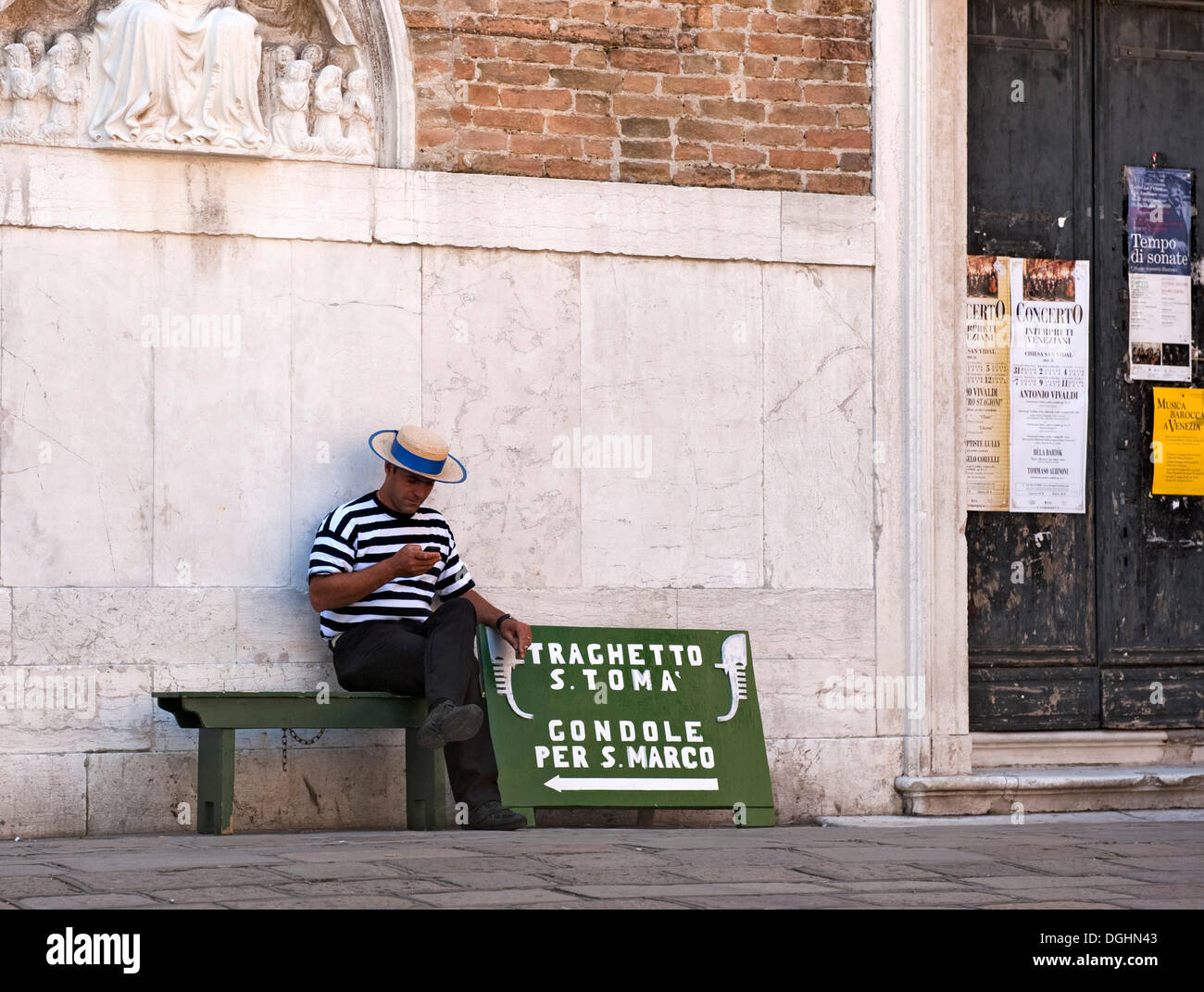 Gondolier sitting on a bench for gondoliers, waiting for customers, sign for gondolas in Venice, Veneto, Italy, Europe Stock Photo