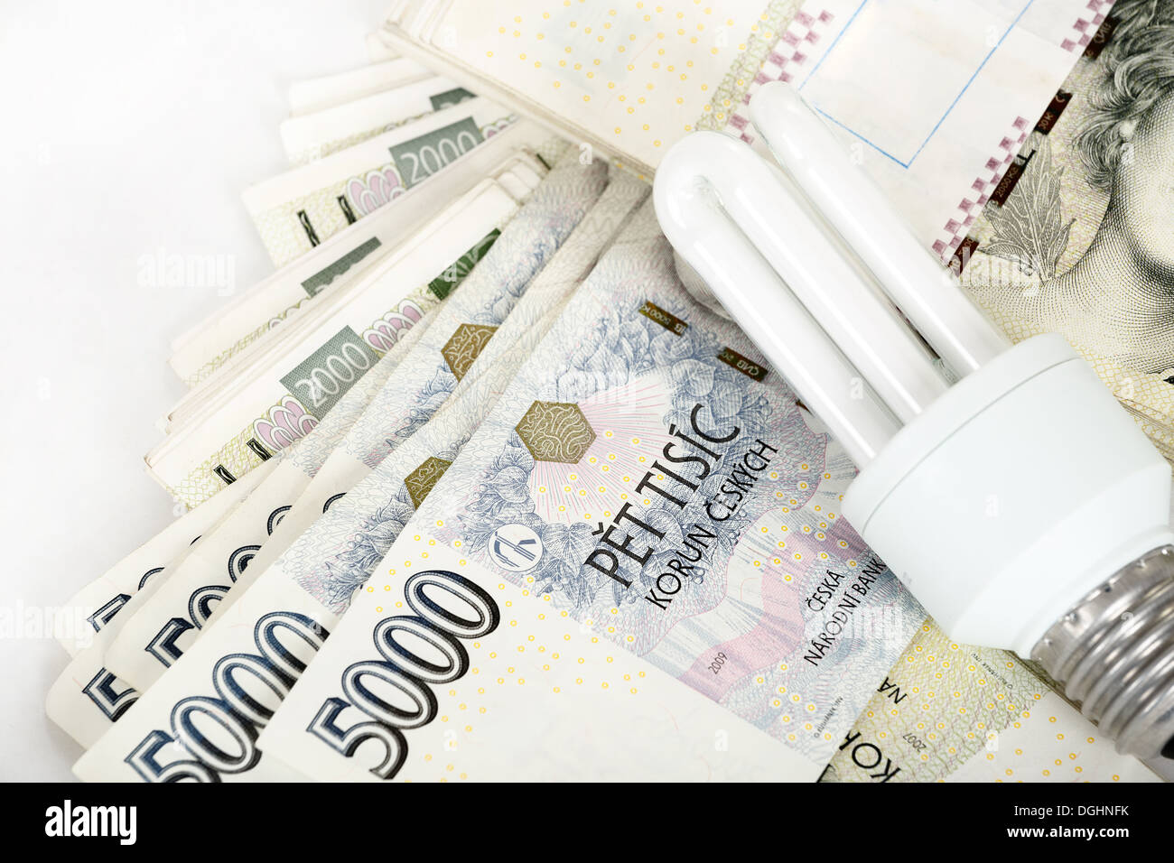 saving money with energy saving bulb concept with czech banknotes crown Stock Photo
