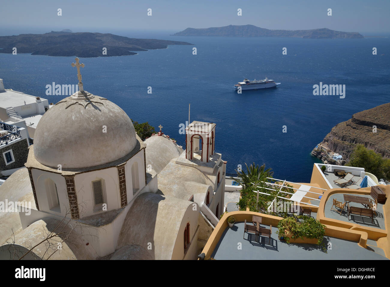 View from the crater rim across the rooftops of Firá or Thira into the Caldera, Ágios Ioánnis church at front, Santorini Stock Photo