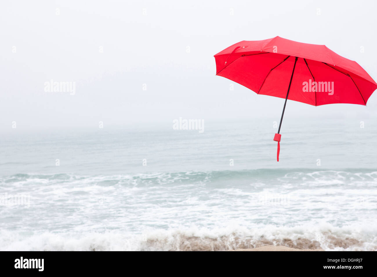 a red umbrella flying on the beach Stock Photo Alamy
