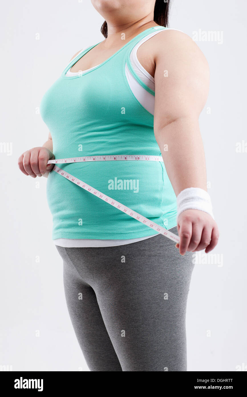 a fat girl in a gym outfit measuring herself Stock Photo Alamy