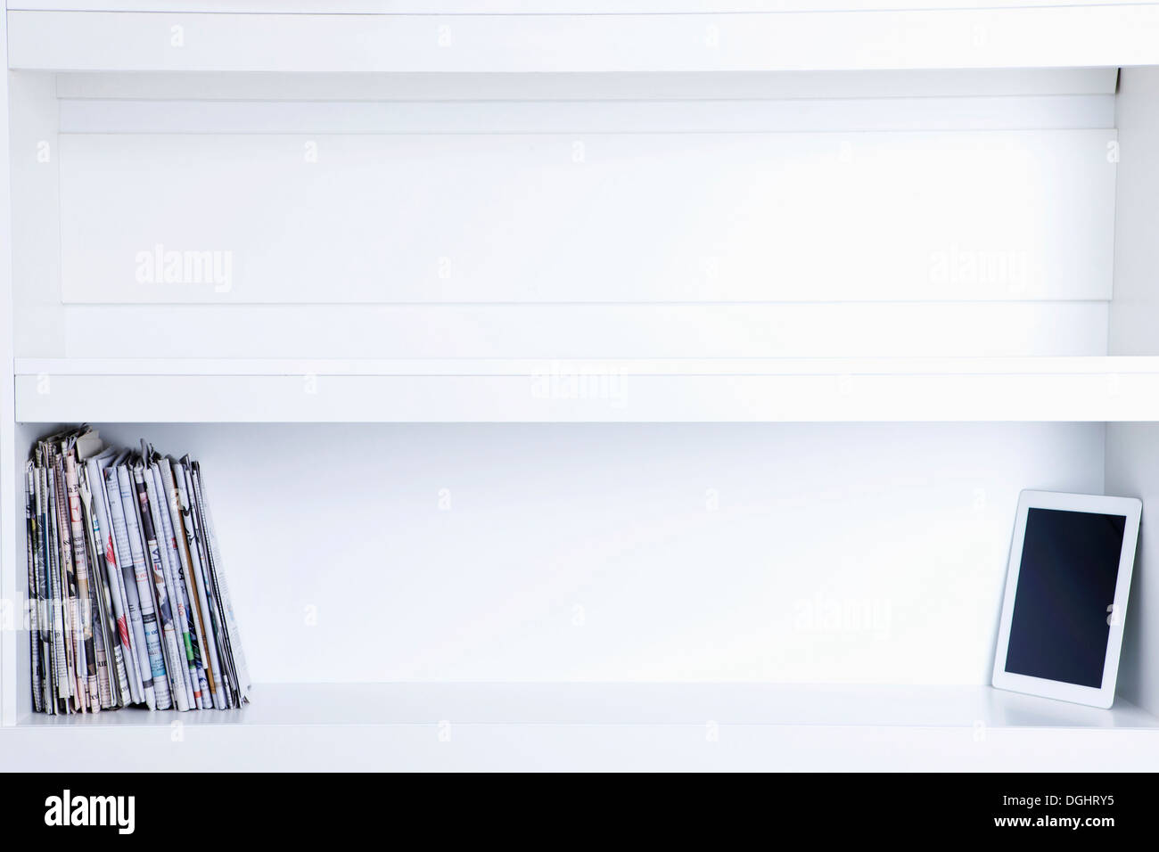 a tablet on a shelf with magazines Stock Photo Alamy