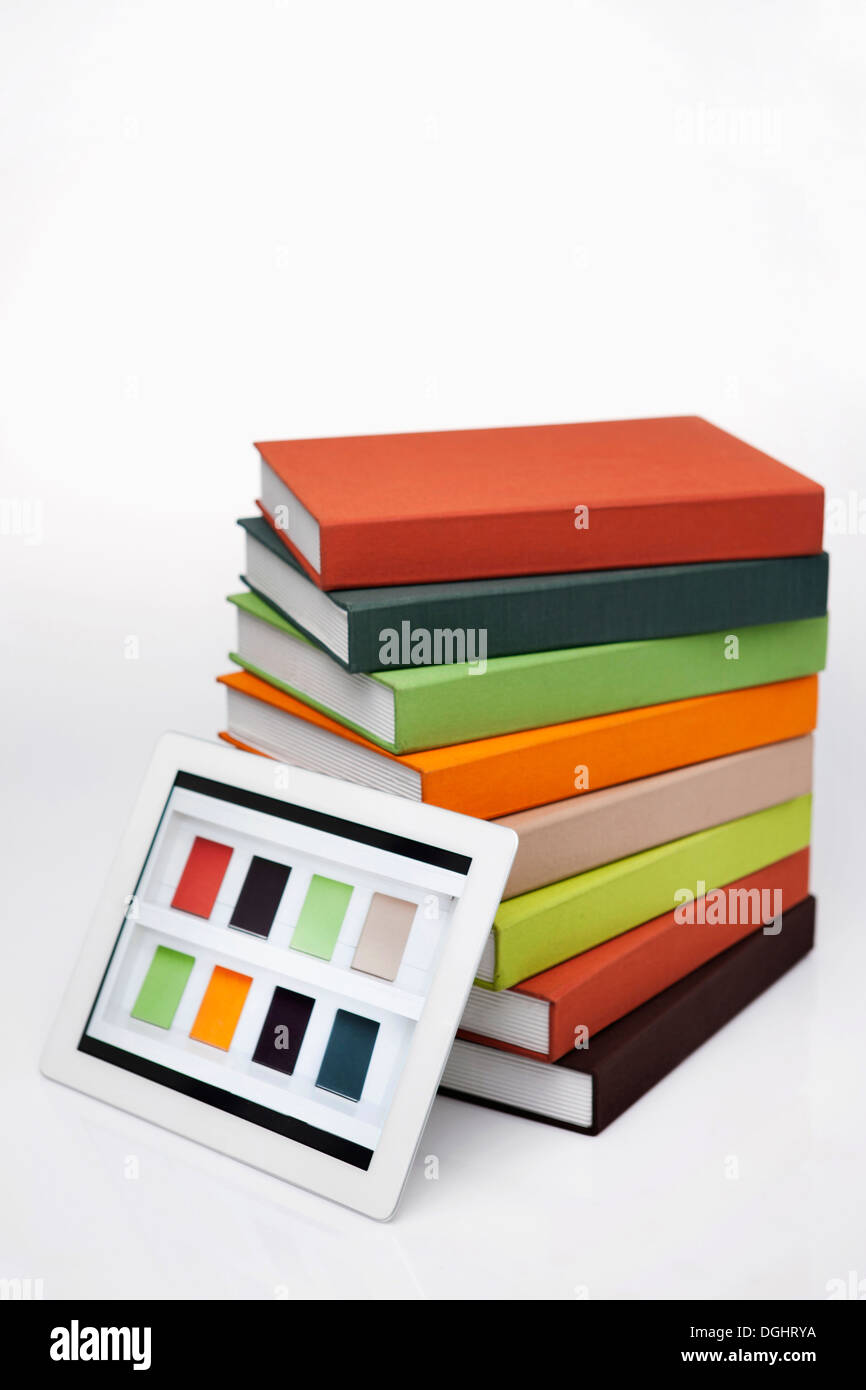 a tablet leaning on a pile of books Stock Photo - Alamy