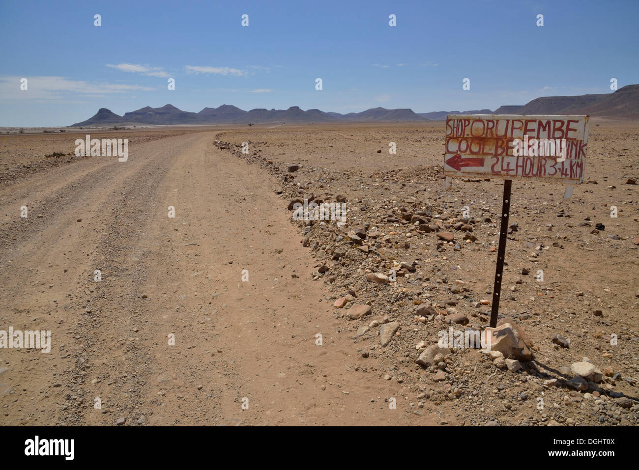 Hand-painted advertising sign for a liquor store on a dirt road in a barren landscape, Orupembe, Kaokoland, Kunene, Namibia Stock Photo