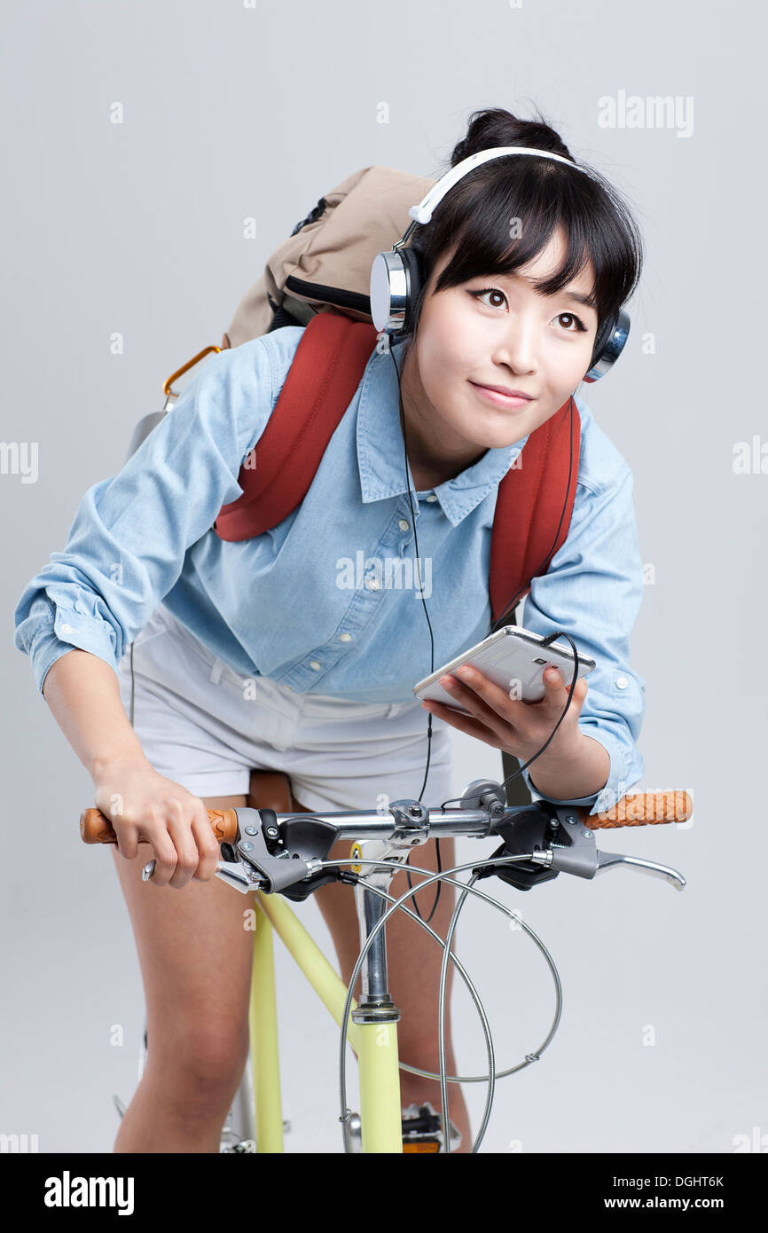 a woman sitting on a bicycle listening to music Stock Photo Alamy