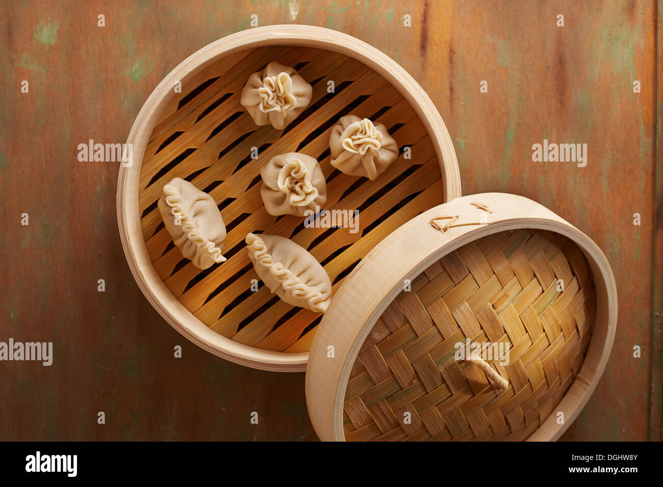 Homemade dim-sum asian dumplings on a traditional bamboo steamer Stock Photo