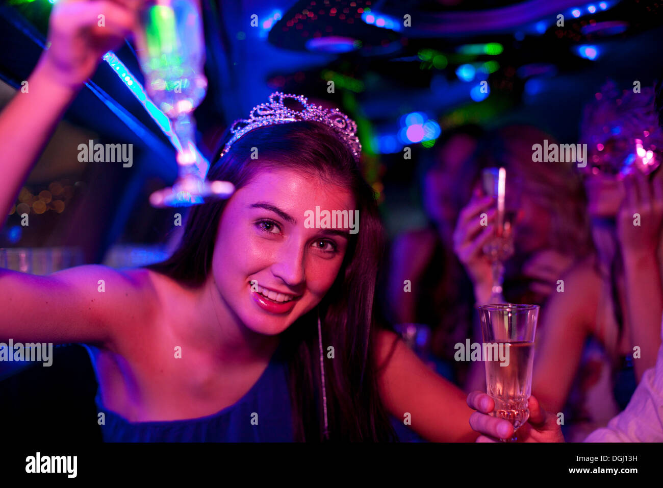 Young woman wearing tiara with wine glass in limousine Stock Photo