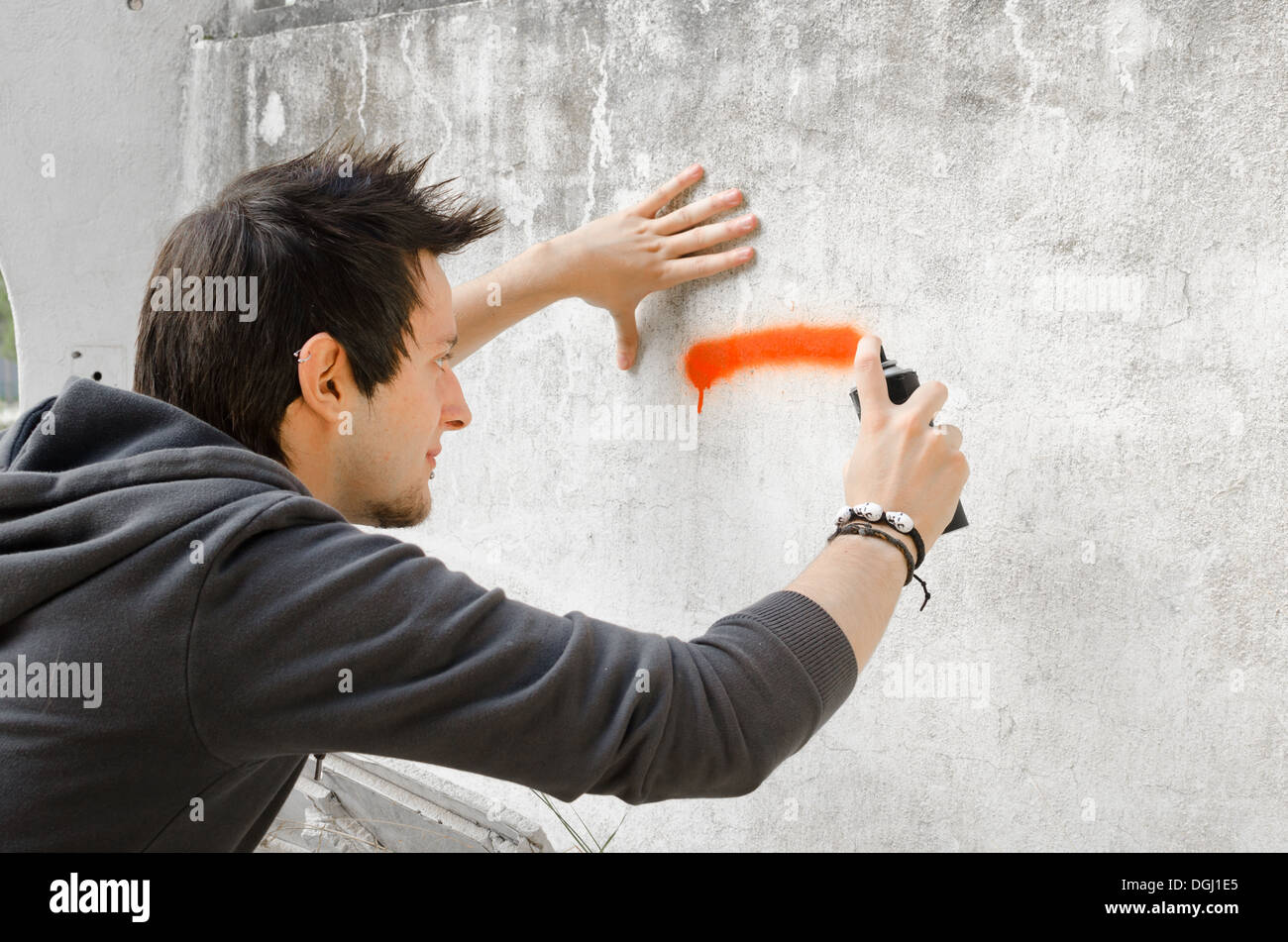 Male teen painting wall spray paint hi-res stock photography and images
