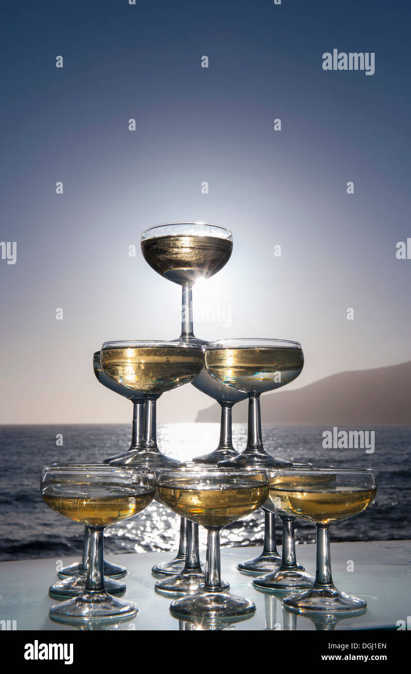 Champagne glasses in pyramid shape with sea in background Stock Photo
