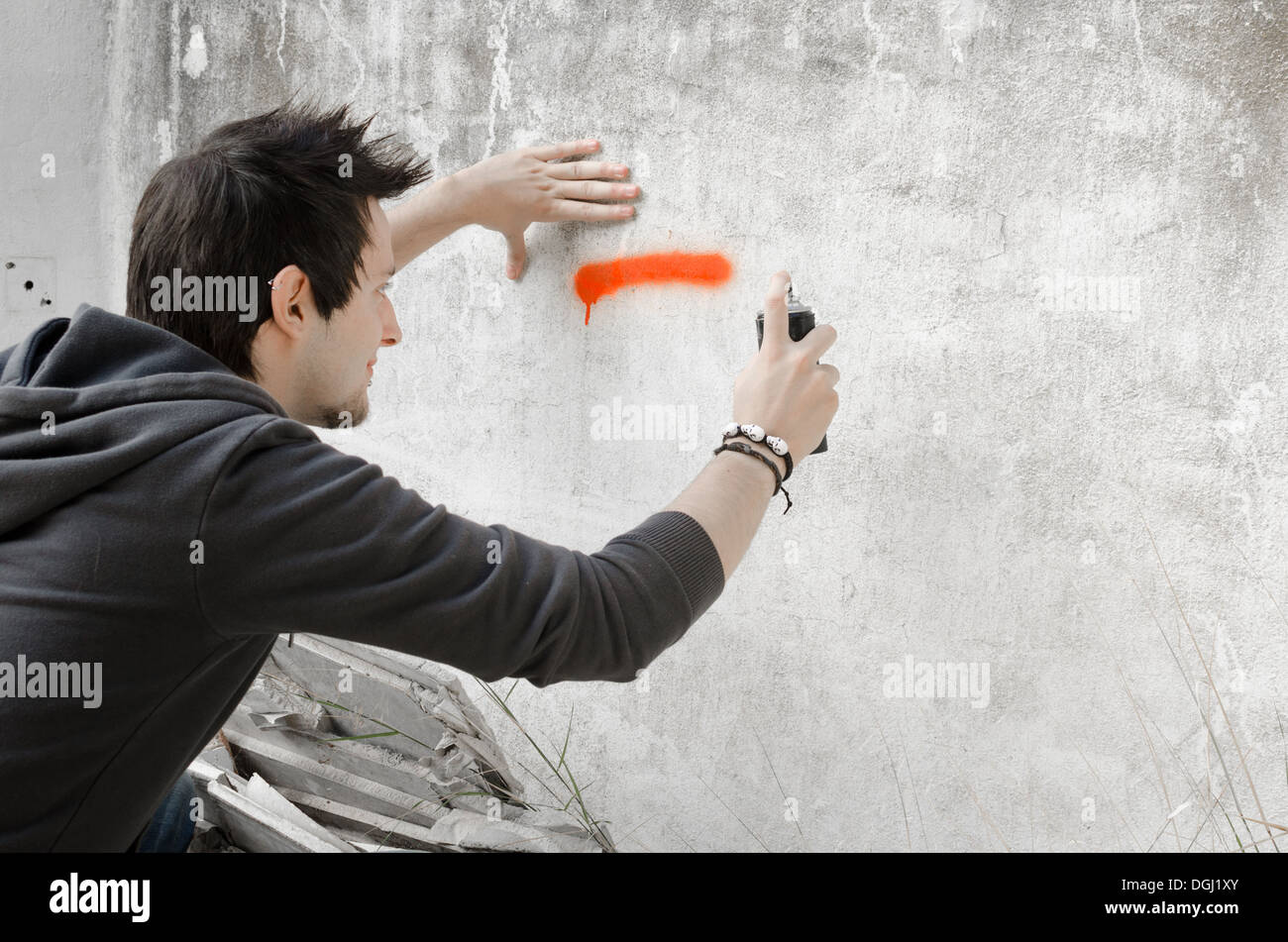 Male teen painting wall spray paint hi-res stock photography and images