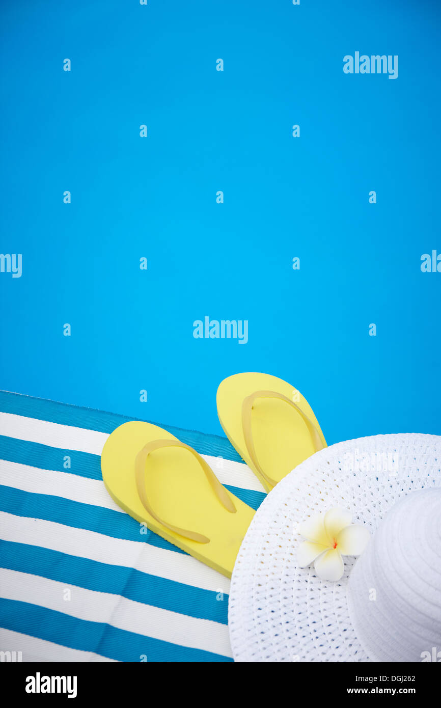 a sun hat and flip flops next to the pool Stock Photo - Alamy