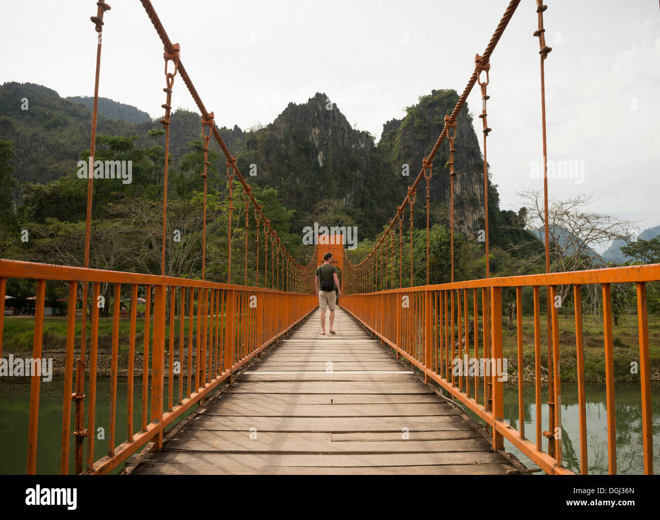 Man on bridge over river, Vang Vieng, Laos Stock Photo