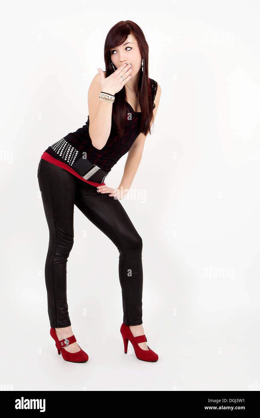Young woman wearing a black top, leggings and red patent leather high heels  posing as a pin up girl Stock Photo - Alamy