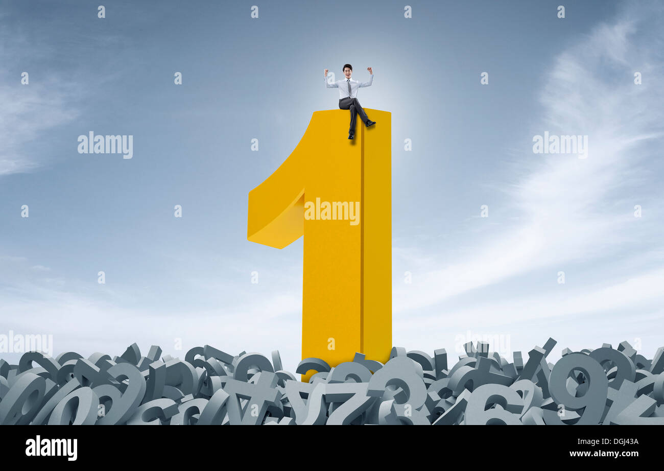 a business man sitting on top of the number one Stock Photo - Alamy