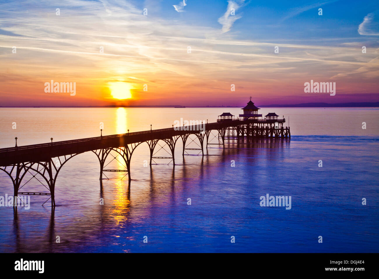The sun sets over the Bristol Channel behind the pier at Clevedon in Somerset. Stock Photo