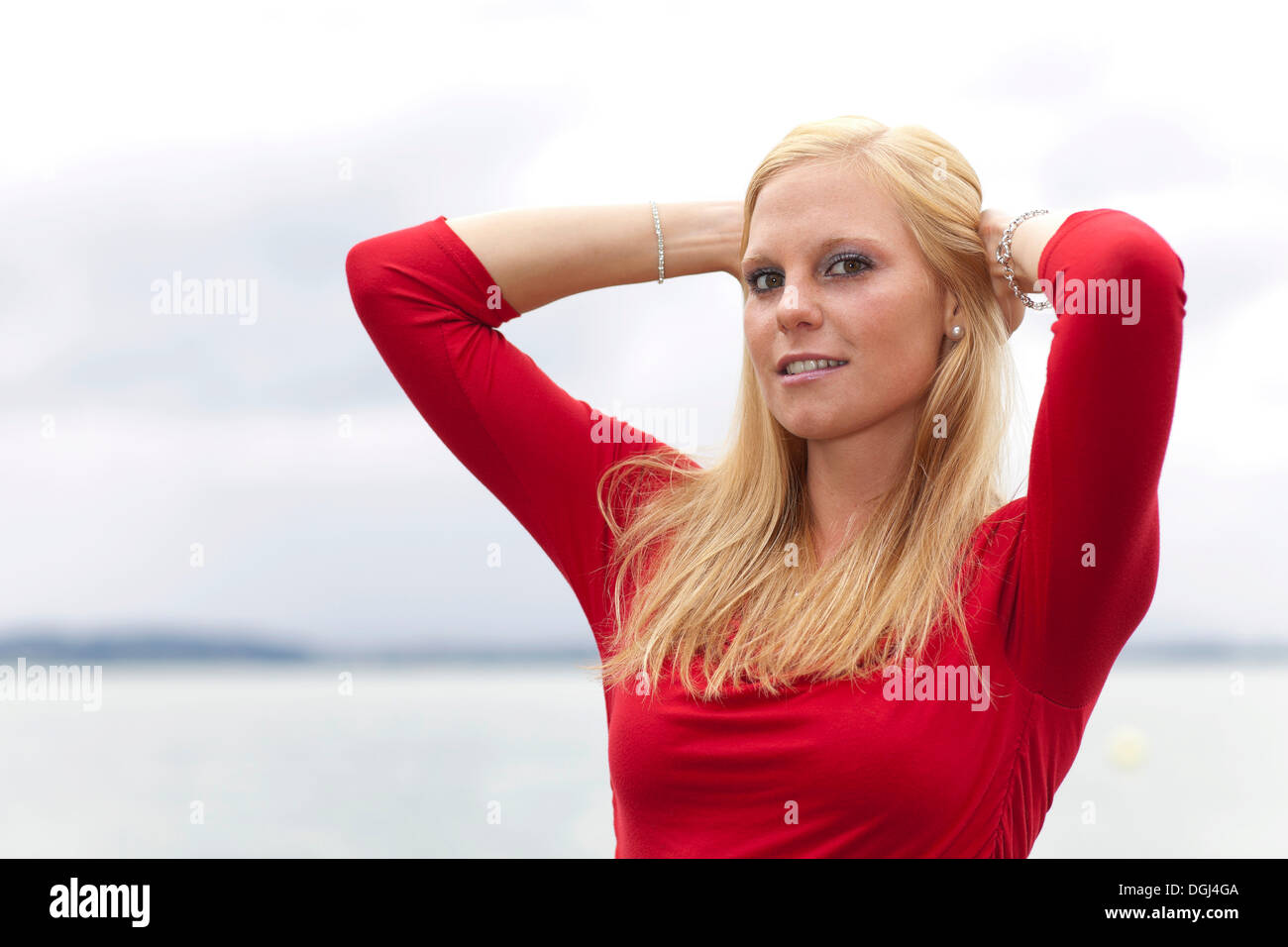 Smiling young woman running her hands through her hair, portrait Stock