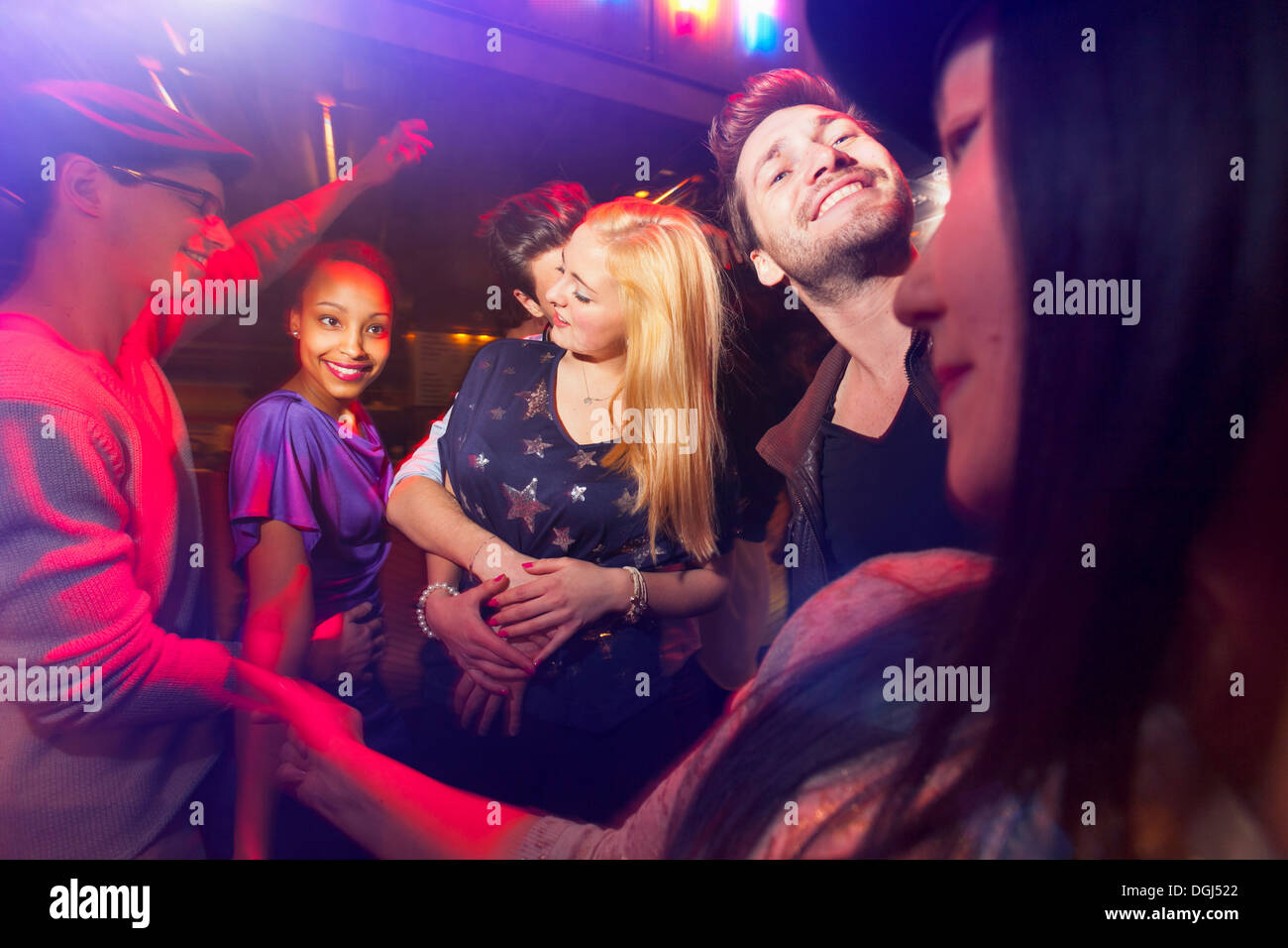 Group of people at party, man kissing woman's neck Stock Photo
