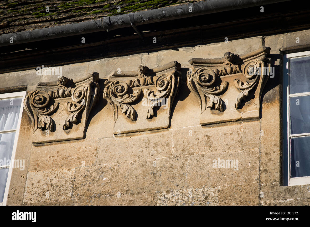 Decorative details on upper front wall of a stone cottage in Lacock village UK Stock Photo