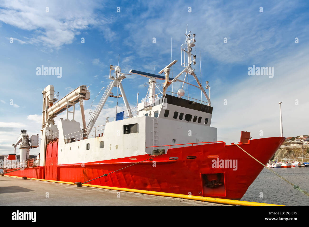 Red freight pallet carrier ship stands moored in Norway coastal town Stock Photo