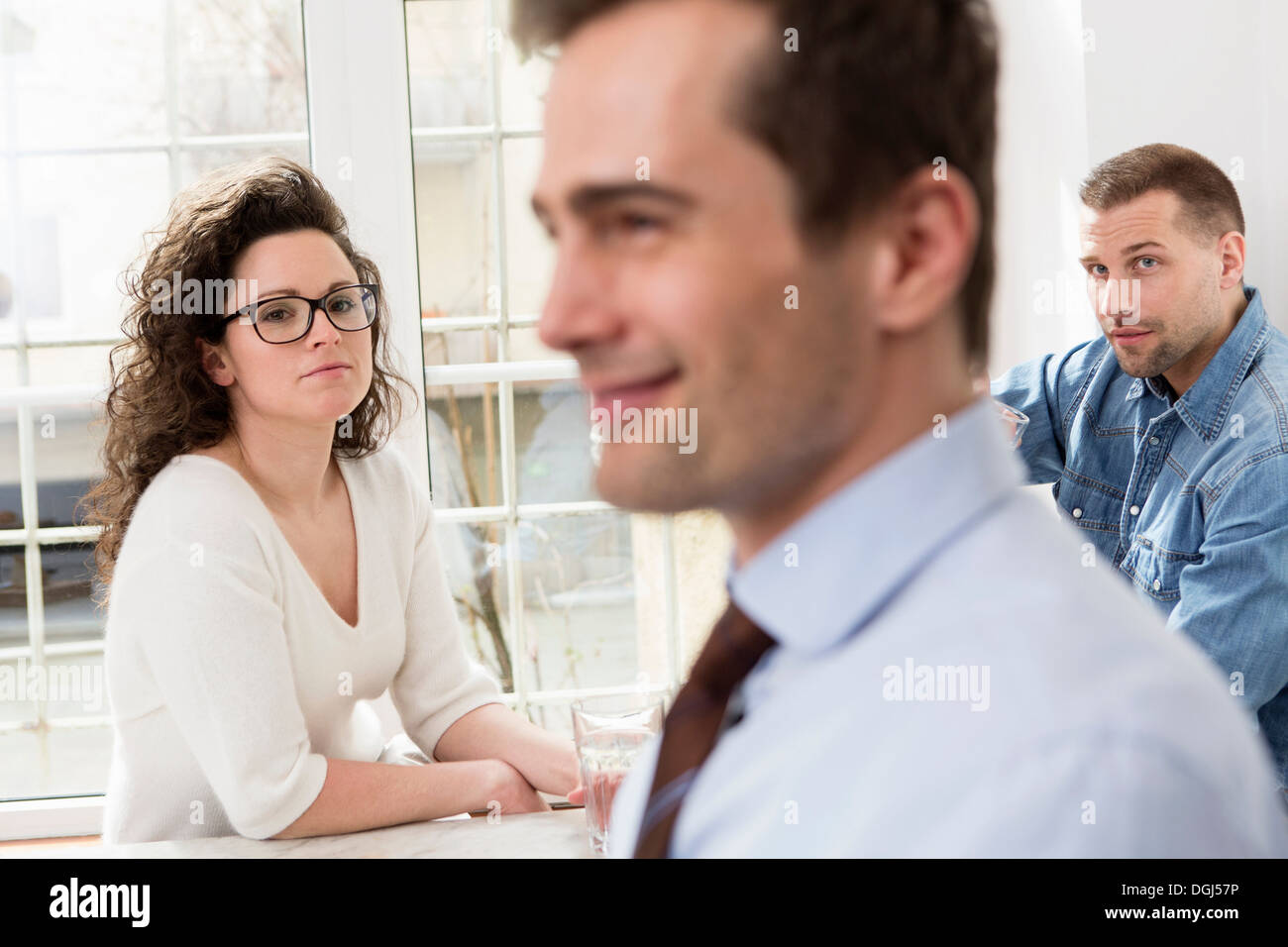 Mature man smiling, mid adults in background Stock Photo
