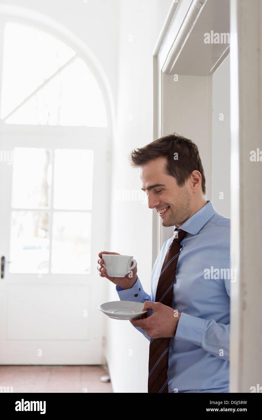 Mature man wearing shirt and tie holding cup of coffee Stock Photo