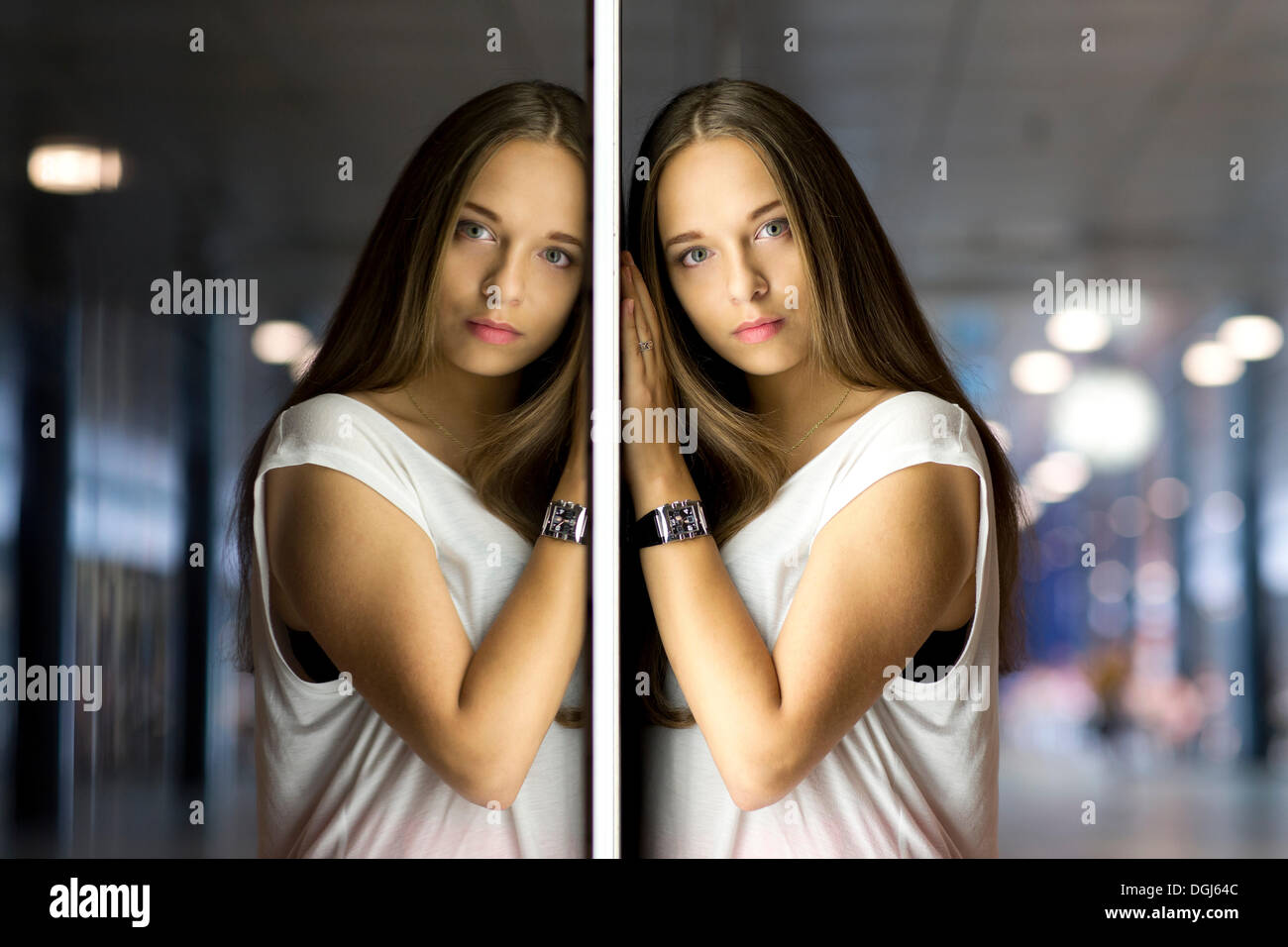 Young woman leaning against a wall of mirrors with her mirrored image Stock Photo Alamy