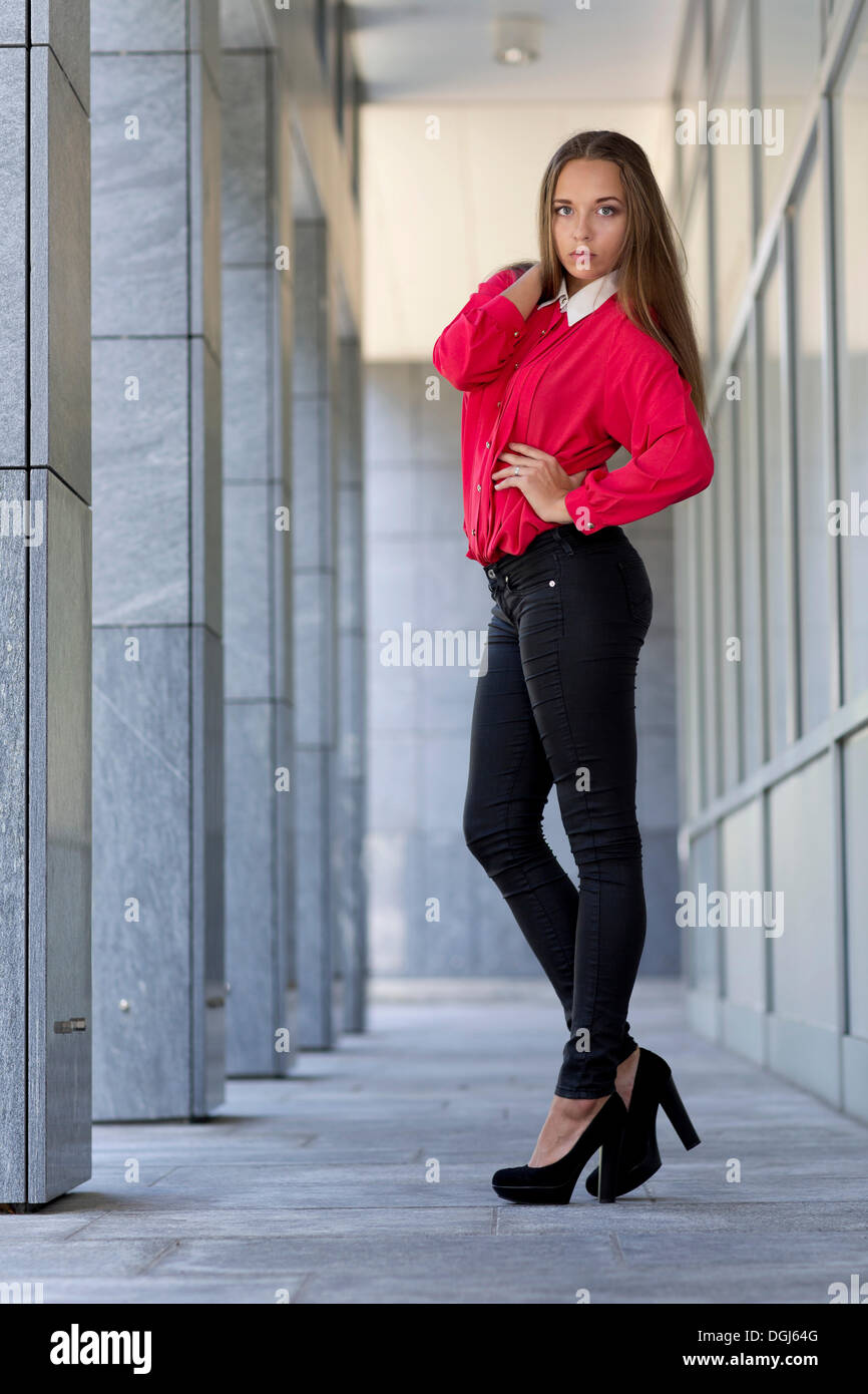 Young woman wearing a red top, black jeans and high heels Stock Photo -  Alamy