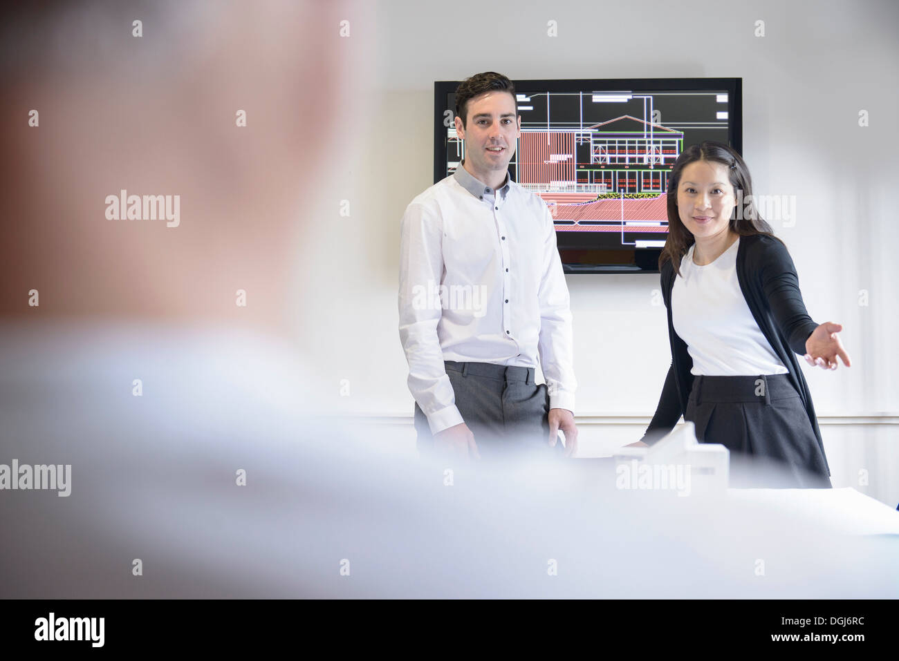 Architects making presentation in boardroom with model building Stock Photo