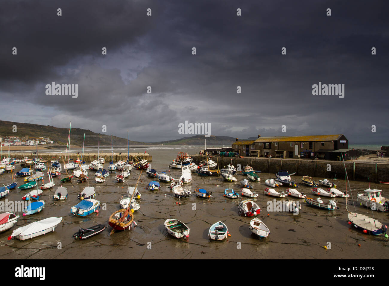 Lyme Regis harbour at low tide on a stormy day. Stock Photo