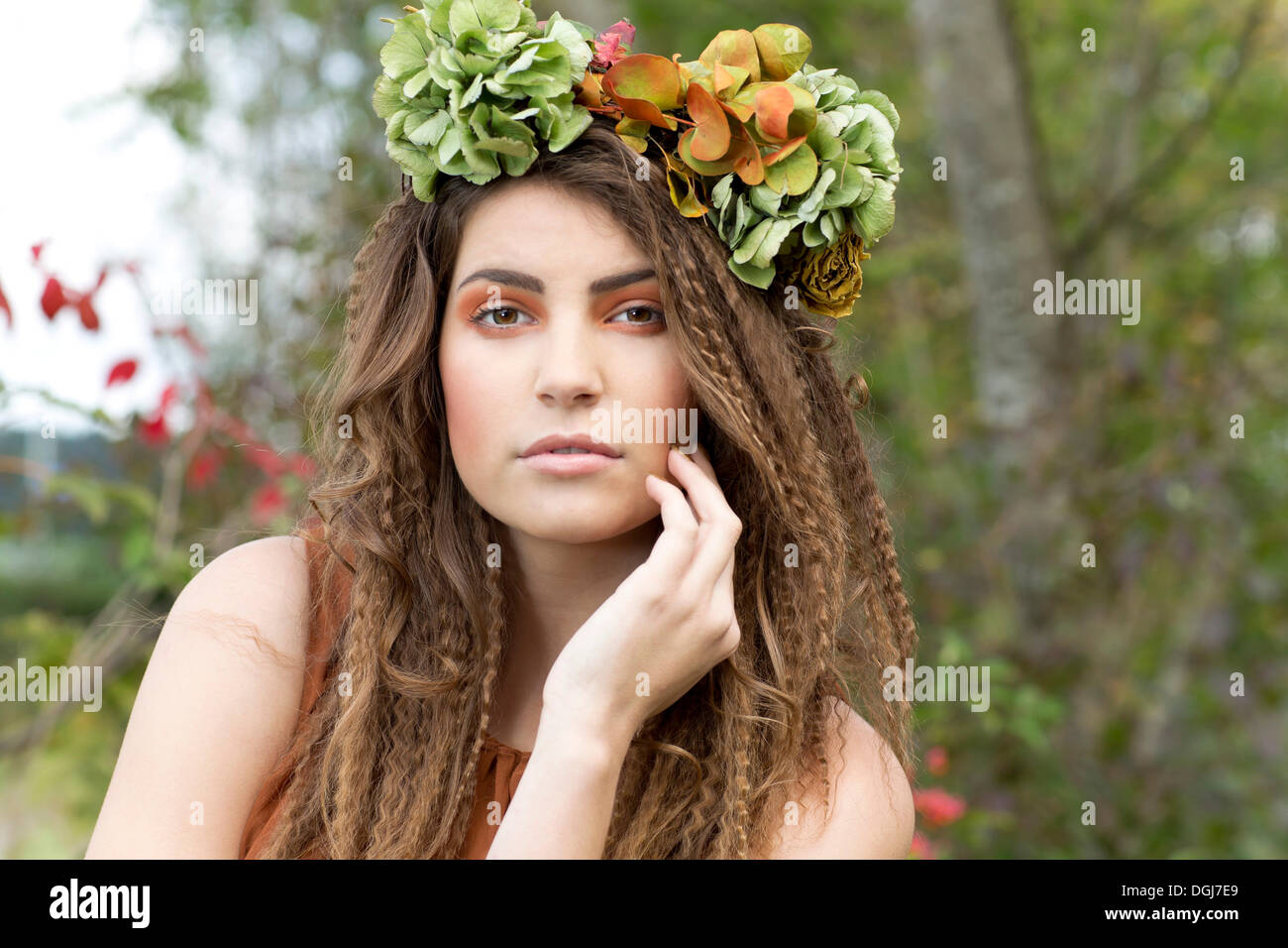 Young woman with a flowal wreath in her hair, outdoors, portrait Stock Photo