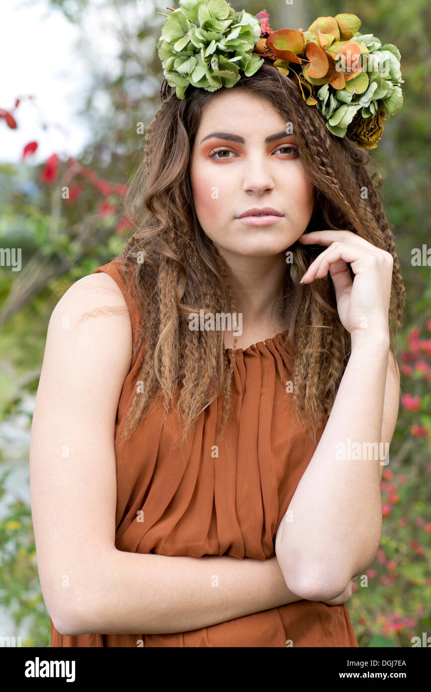 Young woman with a flowal wreath in her hair, outdoors, portrait Stock Photo