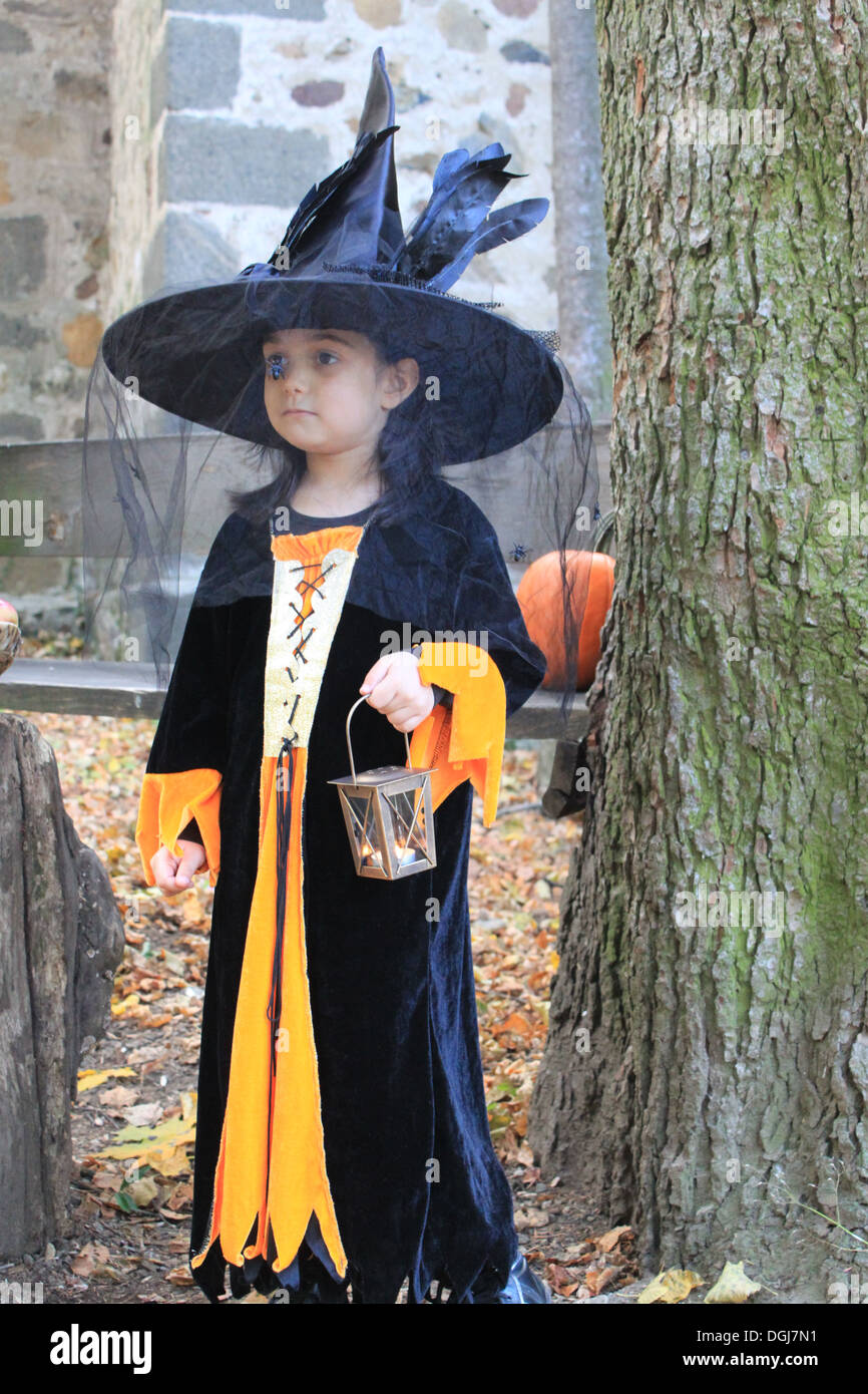 Halloween Tric-or-Treater in her costume with pumpkin Stock Photo