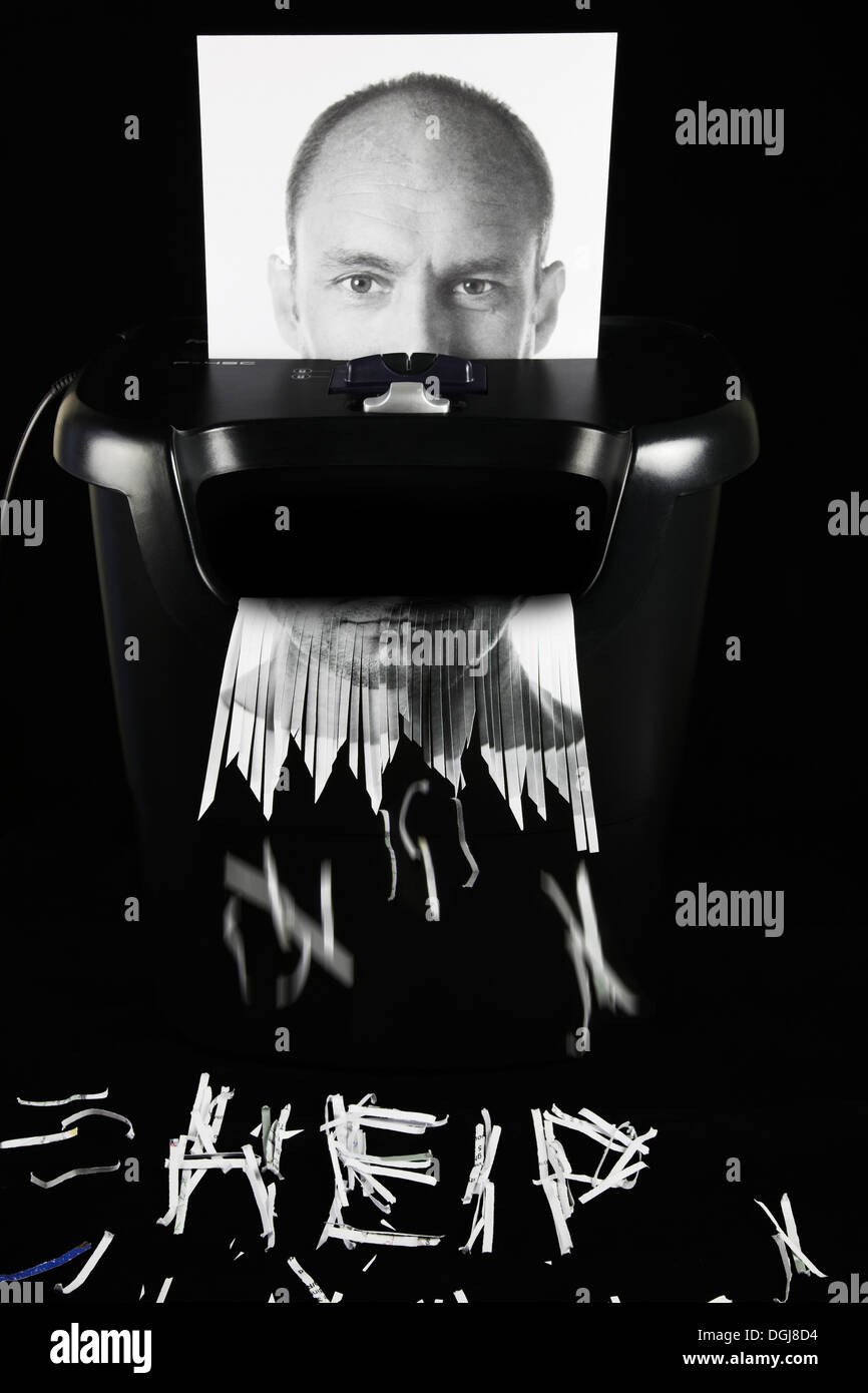 Photograph of a man's face being put through a paper shredder. Stock Photo