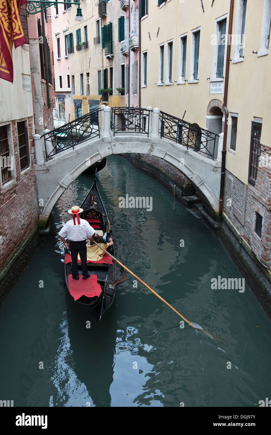 Gondola waiting to go under a bridge on a Venetian canal. Stock Photo