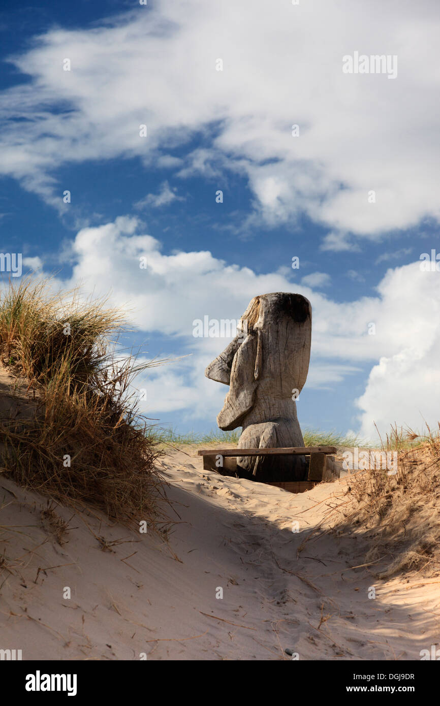 A giant carved wooden head on Barmouth dunes. Stock Photo