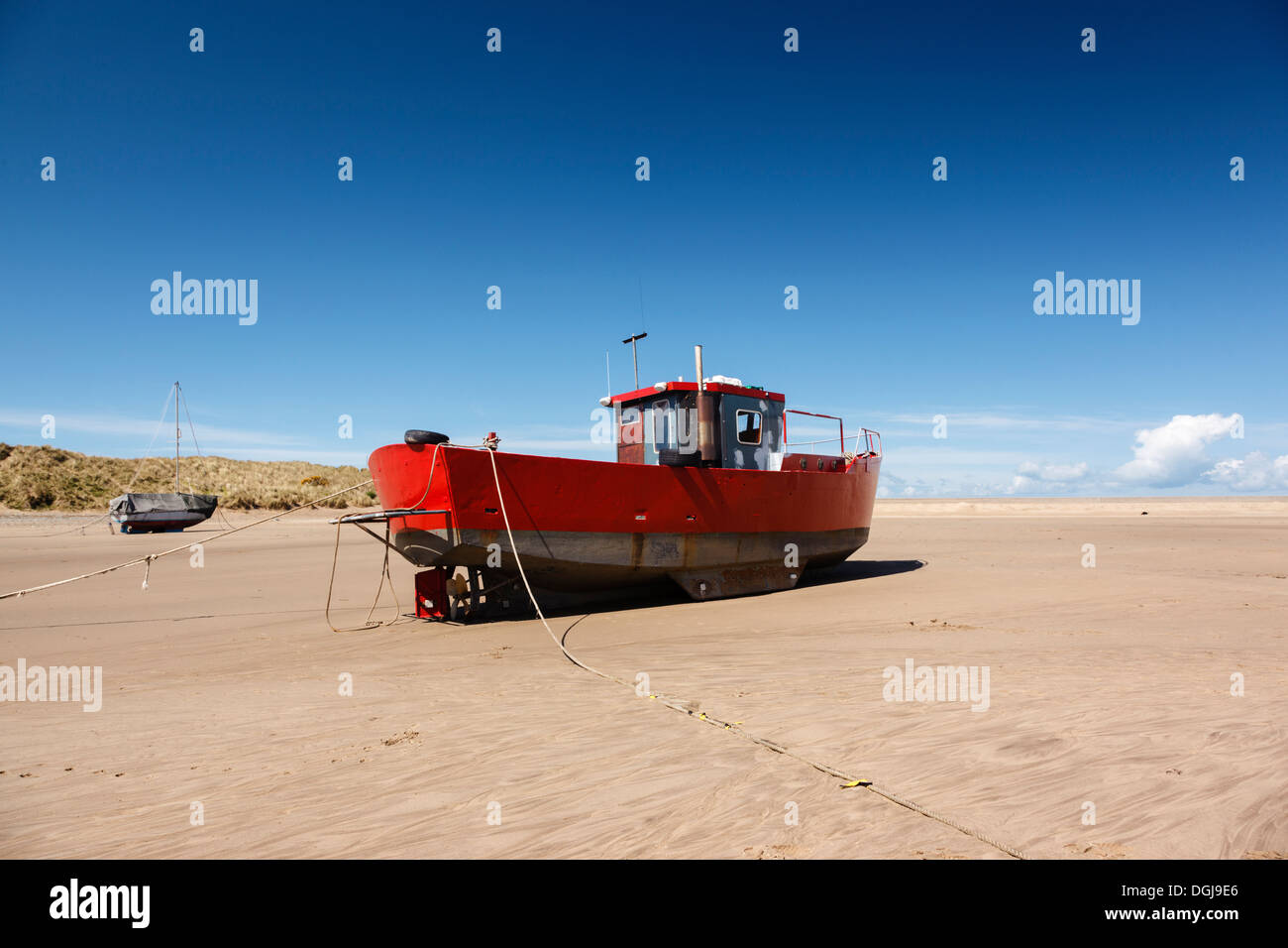 A red fishing boat beached at Barmouth. Stock Photo