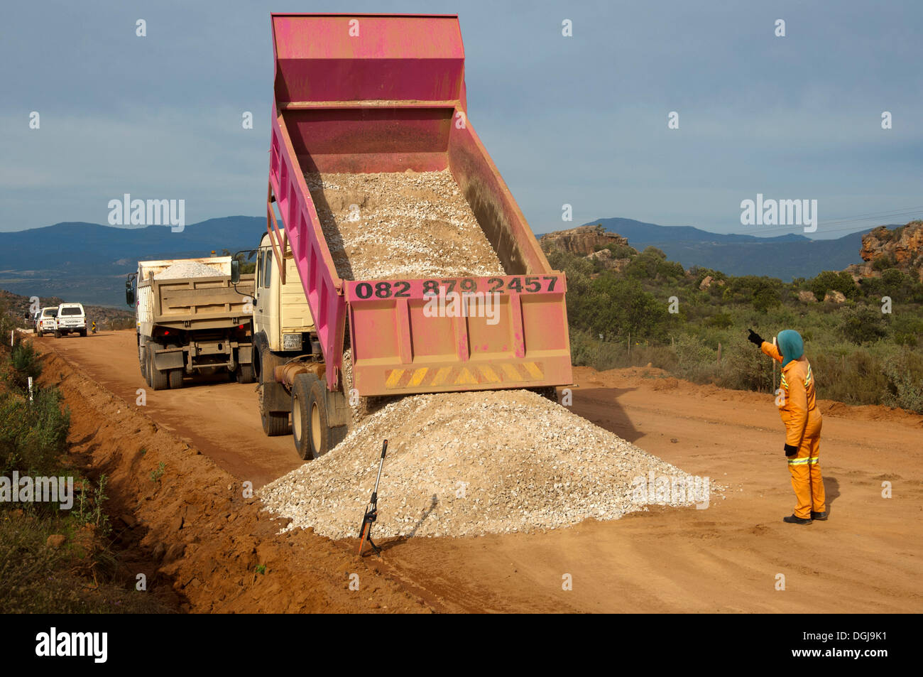 Dump truck unloading gravel on a street, road construction in the Stock
